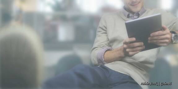 Mann mit Tablet lehnt sich zurück: Passende Anfragen kommen über die Webseite